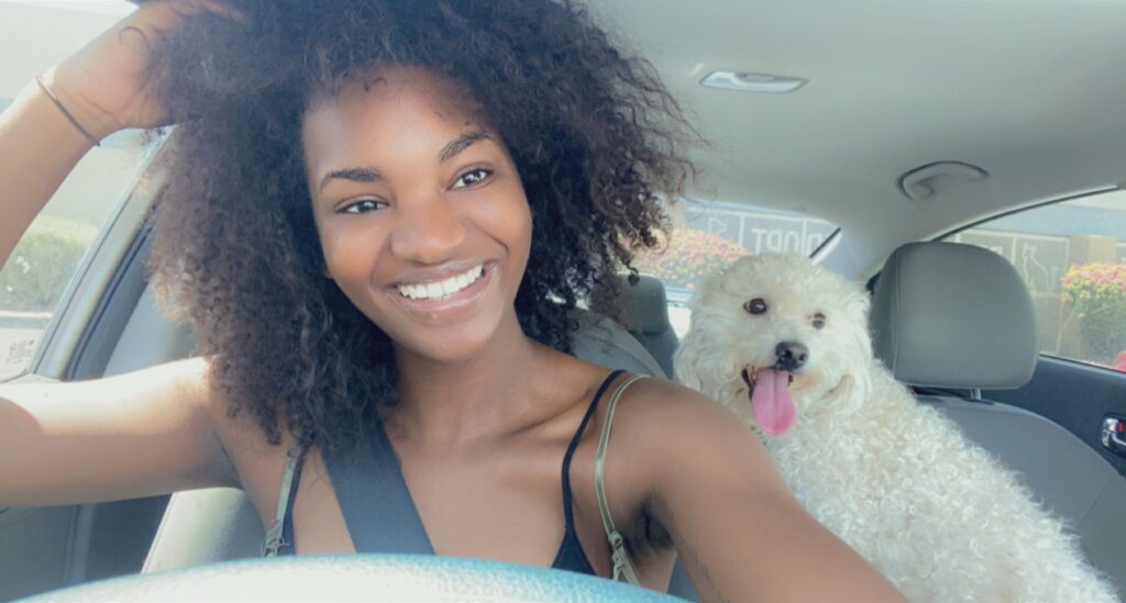 woman taking a selfie in the car with her dog