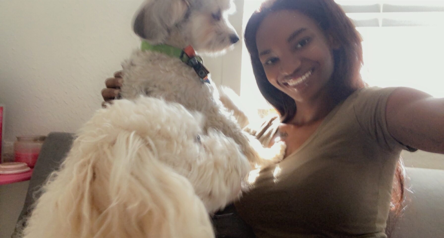 woman taking a selfie with her dog sitting on the couch