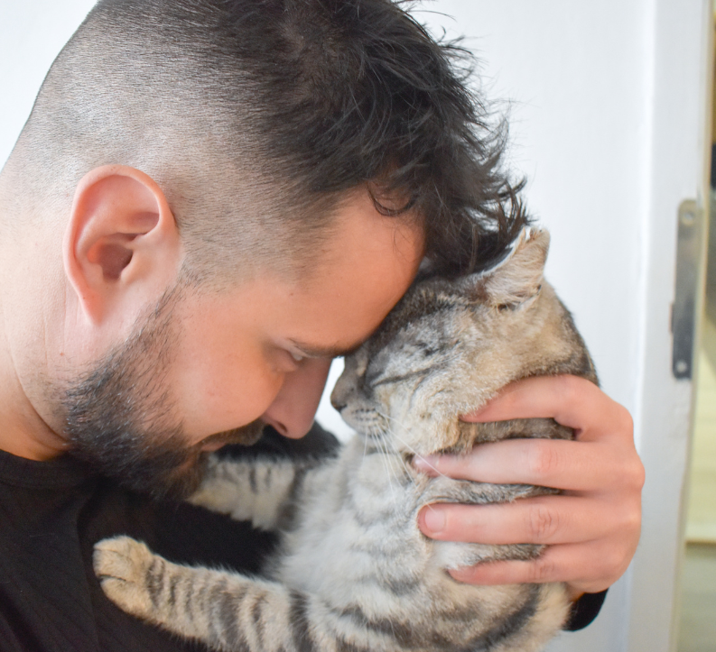 man leaning in cuddling his cat